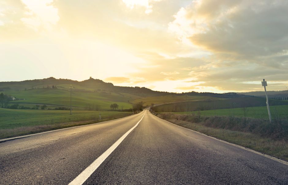 Beautiful empty road in Tuscany, Italy at sunset. Capturing the serene rural landscape and rolling hills.